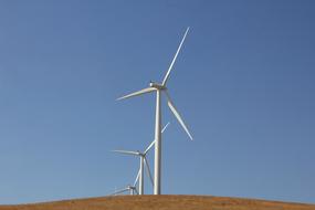 White wind turbines on the colorful hill