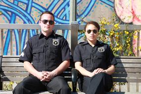 two policemen on a bench on a sunny day