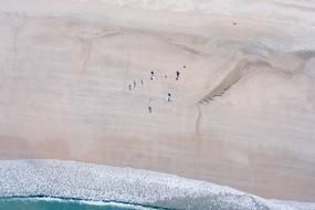 people relaxing on the beach near the sea