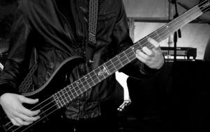 Black and white photo of the musician with the electric bass guitar