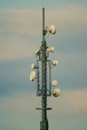 Close-up of the radio antenna, at colorful and beautiful sky with clouds on background