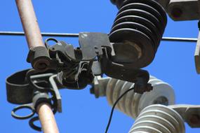 Close-up of the electricity cables, at background with the beautiful blue sky