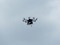 Flying hexacopter, at beautiful cloudy sky on background