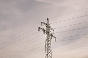 pole with power lines on the background of the cloudy sky