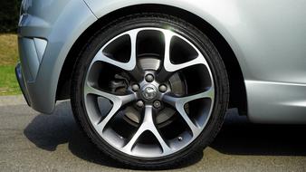 Close-up of the wheel of the glossy, metallic Vauxhall Corsa car, with the shadow, in light