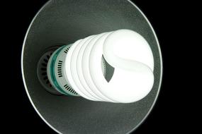 Close-up of the glowing CFL lamp, at black background