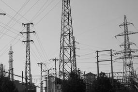 Black and white photo of the landscape of the electric towers, under the cloudy sky in Barcelona, Spain