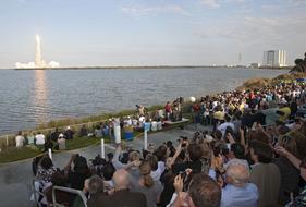 People on the shore, taking photos of the rocket launch, in Florida, USA