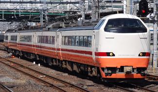 Orange, white and red Nikko Omiya train, on the railway in Japan