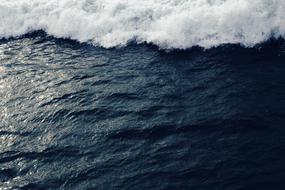 white foam over deep blue water, sea surf