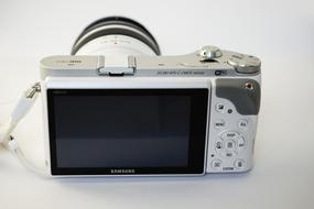 White and grey "Samsung NX 300" camera, with the display and buttons