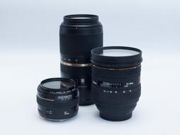 three black Canon Eos 5D camera lenses