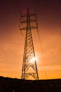 Silhouette of the electricity pylon, on the landscape, at colorful and beautiful sunset with the clouds, in the sky