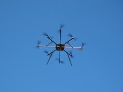 Flying drone, in motion, under the blue sky