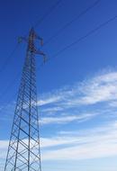 Construction of the electricity towers, with the cables, at blue sky with white clouds on background