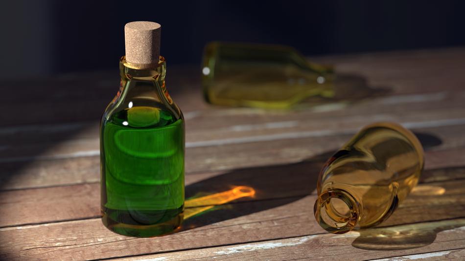 Bottle with Clear Liquid and empty bottles on wooden table