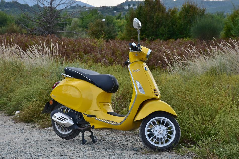 yellow Vespa Roller parked in countryside