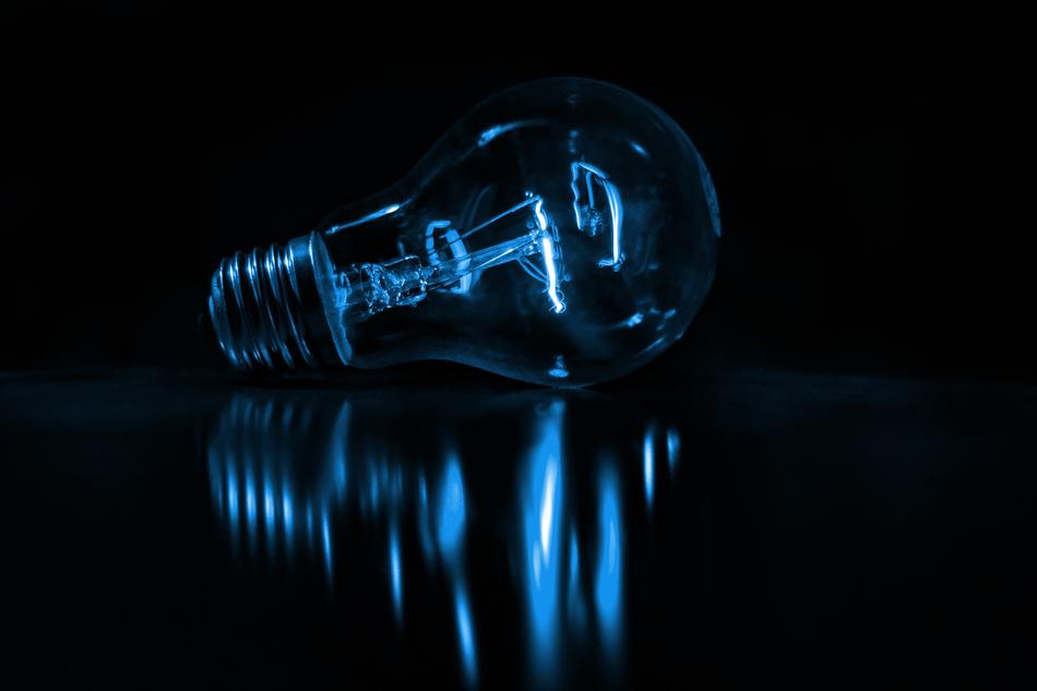blue light bulb reflected in black surface