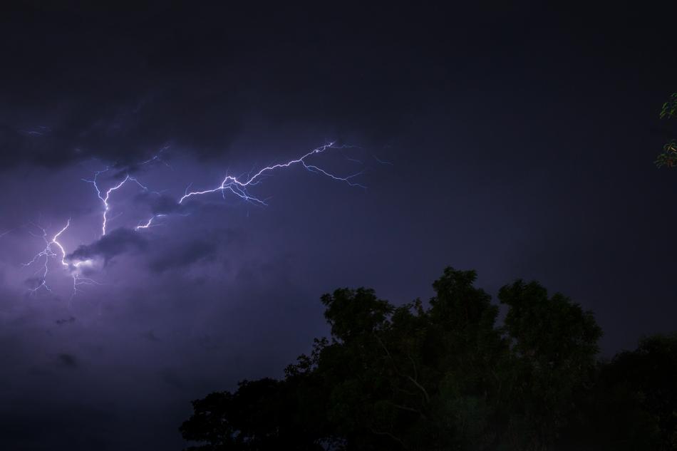 flash of lightning in the stormy sky over the forest
