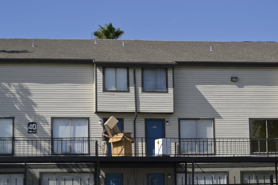 man unpacking Washing Machine on balcony