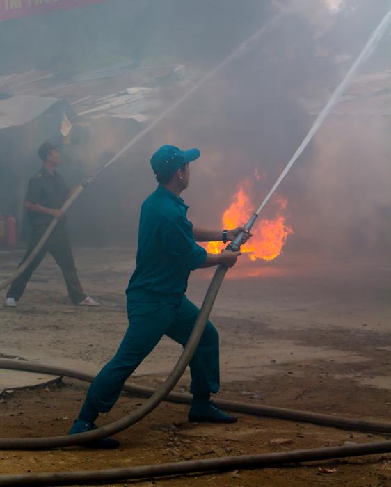 firefighters, two men with hoses extinguish fire