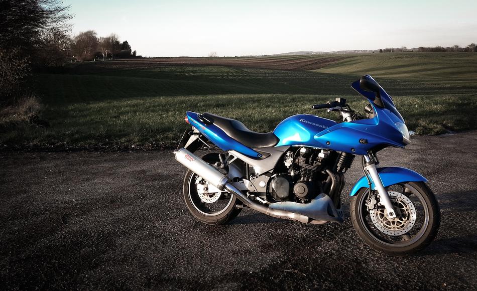 photo of a blue motorcycle in the countryside