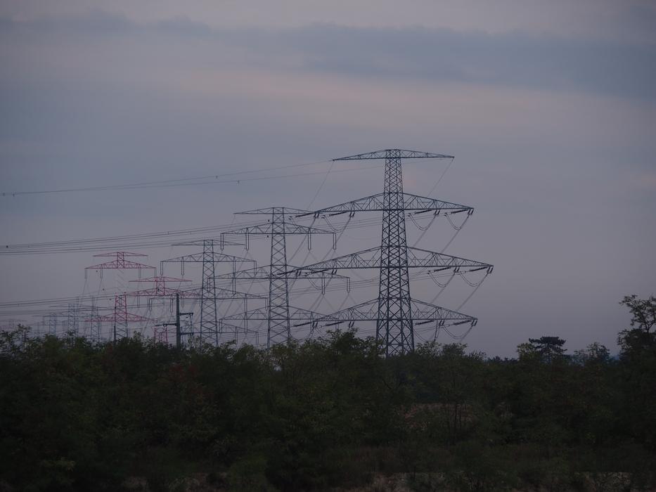 row of transmission masts at dark sky