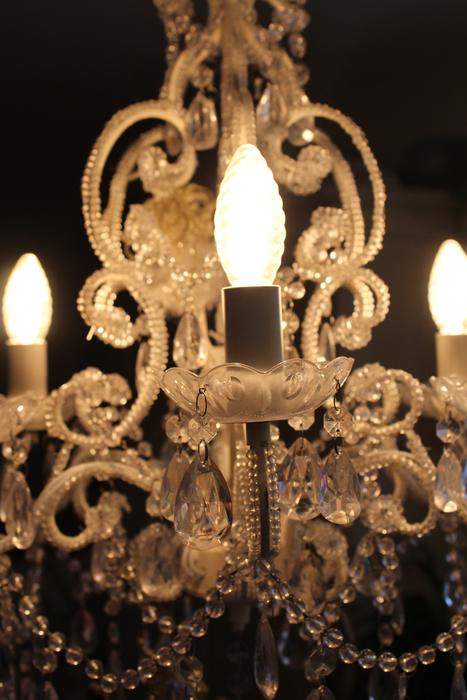 Beautiful, ornamental chandelier with the lights, among the darkness