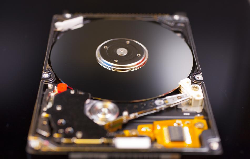 Close-up of the colorful, shiny hard disk, on the black surface, in light