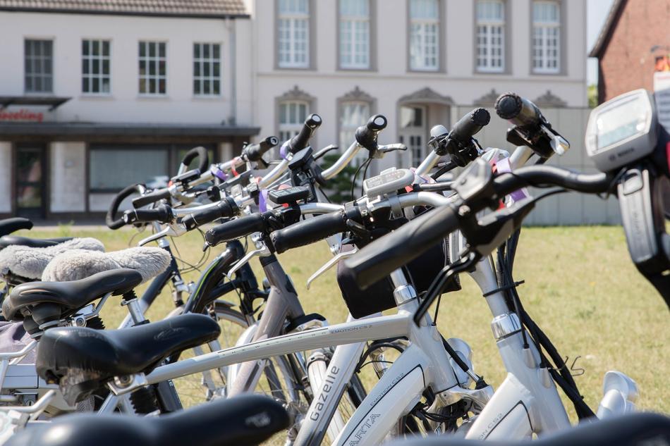 Electric bikes near the green field in light