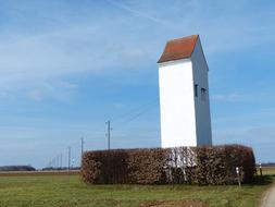 house as a white tower in a field