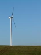 White pinwheel, on the beautiful, green and yellow field, at blue sky on background