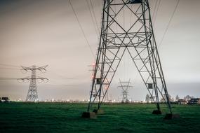 Electricity towers on the green fields, with the colorful and beautiful lights