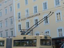 Upper lines of the trolley bus, near the colorful buildings, on the street