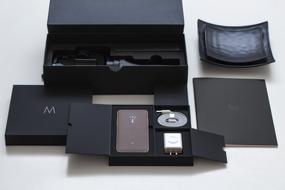 Beautiful cellphone with the charger, in the beautiful case, on the white surface