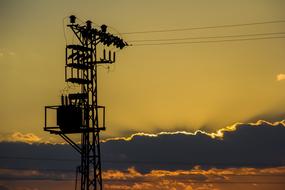 Electric tower, at beautiful and colorful sunset in the clouds