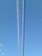 Close-up of the electricity wires, in white snow, in the winter, under the blue sky