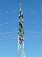 Top of the electricity pylon with cables, at beautiful blue sky on background