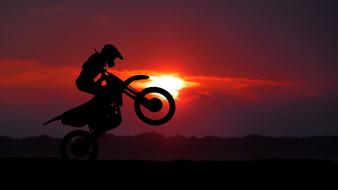 extreme jump of a motorcyclist on a background of red sunset