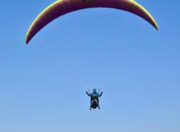 man on a paraglider flies over France