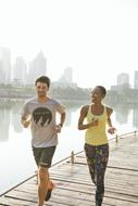 young caucasian boy and african girl jogging together at foggy city