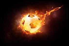 burning soccer ball in darkness