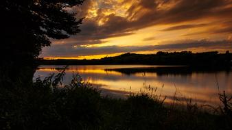 photo of the morning sun and clouds over the lake