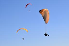 Paragliding, three Paragliders at clean blue sky