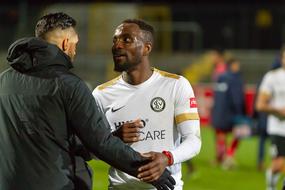Kevin Koffi talks with a coach at the stadium