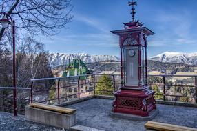 photo of street clock against the background of the Alpine mountains