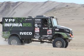 a car at high speed drives through a sand pit