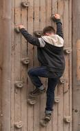 Boy climbs up Climbing Wall