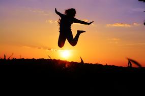 girl jumps over the field at dawn