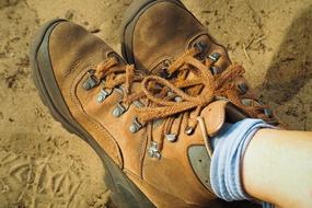 feet in Hiking leather Shoes on sand